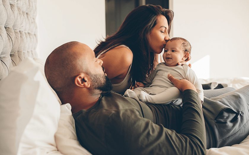 parents with newborn in bed